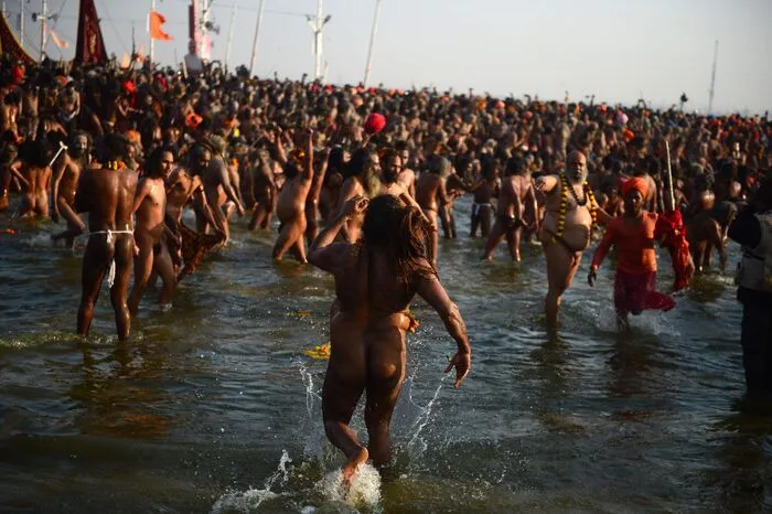 Den zeremoniellen Auftakt machten heilige Männer verschiedener hinduistischer Orden, die bei Sonnenaufgang safranfarben gekleidet ins Wasser stiegen.