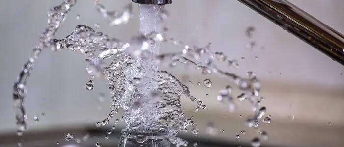 Wasser läuft spritzend aus einem Wasserhahn