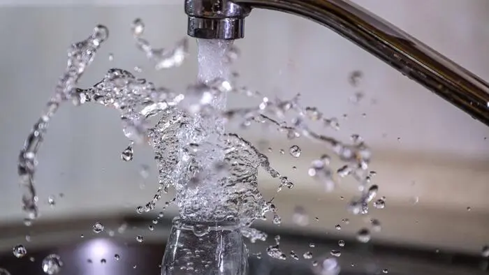 Wasser läuft spritzend aus einem Wasserhahn