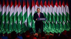 Viktor Orbán vor einem Wall ungarischer Fahnen