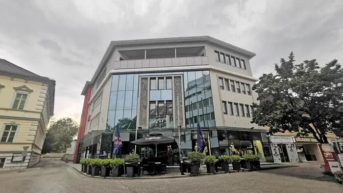 Ein Sitzgarten vor einem großen Gebäude ist zu sehen