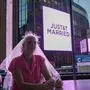 Eine Frau mit Brautschleier steht vor dem Madison Square Garden. Auf der Videowall steht „Just&T married!“