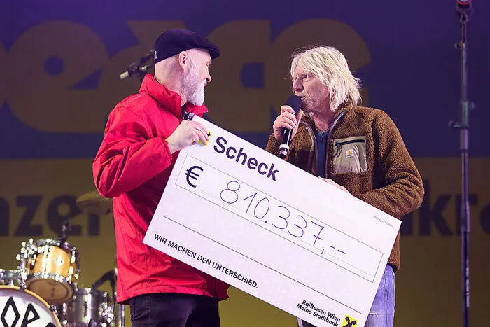 Veranstalter Ewald Tatar (rechts) überreicht Erich Fenninger von der Volkshilfe einen Scheck in beträchtlicher Höhe.