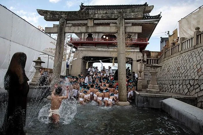 Nach einem reinigenden Bad steigt die Spannung, wenn die Männer in bedrückender Enge im Tempel zusammengepfercht sind. Viele Teilnehmer haben sich mit Bier und dem Reiswein Sake Mut angetrunken.