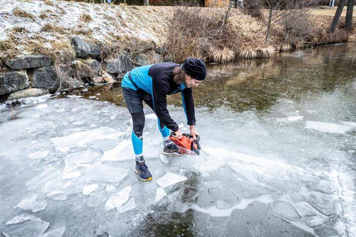 Gerd Bodner schneidet ein Loch in den zugefrorenen See