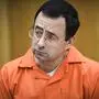 FILE - In this Feb. 2, 2018, file photo, Larry Nassar listens as Melissa Alexander Vigogne gives her victim statement in Eaton County Circuit Court in Charlotte, Mich. The first woman to publicly accuse the now-imprisoned sports doctor of sexual abuse is expected to question USA Gymnastics' chief financial officer during a creditors' meeting two months after the embattled sport organization filed a Chapter 11 bankruptcy petition. (Matthew Dae Smith/Lansing State Journal via AP, File)