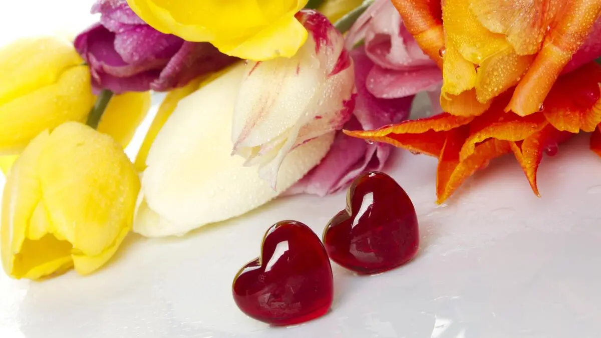 Bunter Blumenstrauß und zwei Herzen | Blumen in warmen Weiß-, frischen Gelb- und intensiv, erdigen Rottönen liegen heuer im Trend