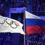 (FILES) In this file photo taken on February 23, 2014 The Olympic flag (L) and the Russian flag flutter during the Closing Ceremony of the Sochi Winter Olympics at the Fisht Olympic Stadium. - The World Anti-Doping Agency (WADA) decided on December 9, 2019, to exclude Russia from the Olympic Games for four years, including Tokyo-2020 and Beijing-2022, to sanction the falsification of test data submitted to the agency, a WADA spokesman said after the Executive Committee meeting in Lausanne. (Photo by Damien MEYER / AFP)