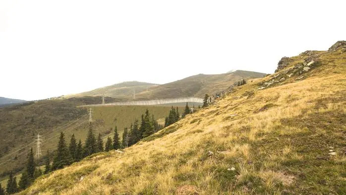 Rendering der Projektwerber zeigt die Borstgraswiesen der Koralm, in die eingebettet ein Speichersee zu sehen ist. Daneben die bestehende 380-kV-Leitung