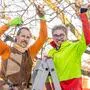 Man sieht zwei Personen in auffallend bunter Kleidung auf einer Leiter stehen und Äste eines Baumes in der Hand haltend | Stefan Wiltschnig (rechts) und Piero Schmid haben den Verein „Obstbaumwart:innen Kärnten/Koroška“ gegründet