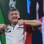 Mensur Suljovic of Austria celebrates as he takes part in a round one match at the World Darts Championships, at Alexandra Palace in London, England, Monday, Dec. 15, 2025. (AP Photo/Kin Cheung)