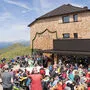 Vor der Sillianer Hütte feiern viele Menschen die Neueröffnung im Jahr 2023