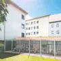 Visualisierung für ein Nachverdichtungswohnprojekt, man sieht ein mehrstöckiges Gebäude in weiß mit Radabstellplätzen davor