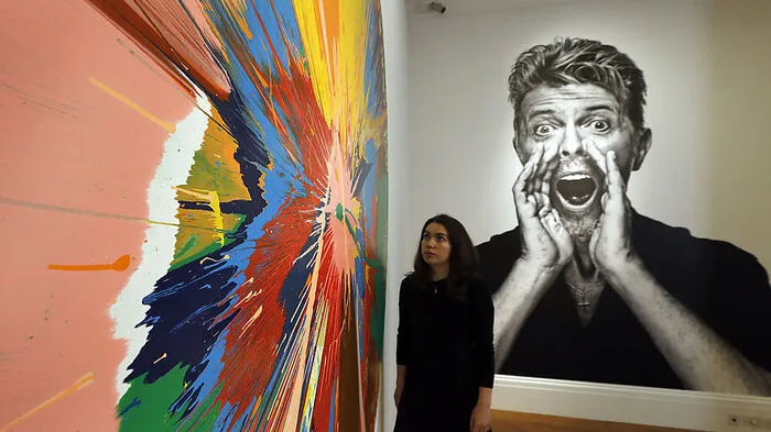 Eine Frau vor einem Bild von  Damien Hirst
