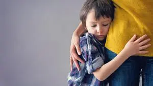 Sad little child, boy, hugging his mother at home, isolated image, copy space. Family concept