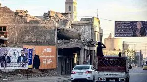Electoral adverts for candidates running in the 2023 Iraqi municipal elections are displayed near the ruins of the historic Roman Catholic Dominican Church of Our lady of the Hour, which was heavily damaged during the battles 2017 with the Islamic State (IS) group fighters, in the old town of Iraq's northern city of Mosul on December 17, 2023 on the eve of the vote. (Photo by Zaid AL-OBEIDI / AFP)