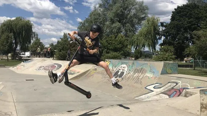 Ein junger Scooter-Fahrer in einem Skate-Park