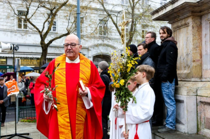Stadtpfarrprobst Christian Leibnitz mit Gläubigen beim Brunnen.
