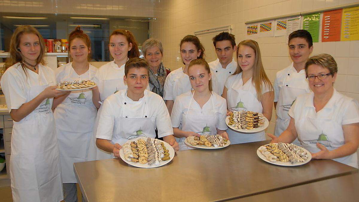 Nina Chiara, Lisa, Julia, Michael, Direktorin Rudolfine Praßl, Janine, Sarah, Marcel, Elisa, Chalil und Elisabeth Eder zeigen stolz die köstlichen Kekse