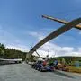 Ein Kran hebt den Rotor eines Windrads von einem Tieflader