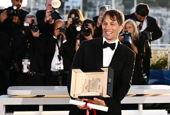 US director Sean Baker poses with the trophy during a photocall after he won the Palme d'Or for the film 