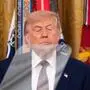 Donald Trump blickt Richtung Teleprompter. Hinter ihm sind Flaggen.