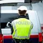 Man sieht einen Polizisten von hinten mit gelber Weste vor zwei Polizeiautos stehen | Im Zuge einer Verkehrskontrolle in Klagenfurt wurden die Beamten auf die Drogen aufmerksam