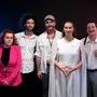 Eine Gruppe von Schauspielern, bestehend aus Männern und Frauen unterschiedlichen Alters, schaut in die Kamera