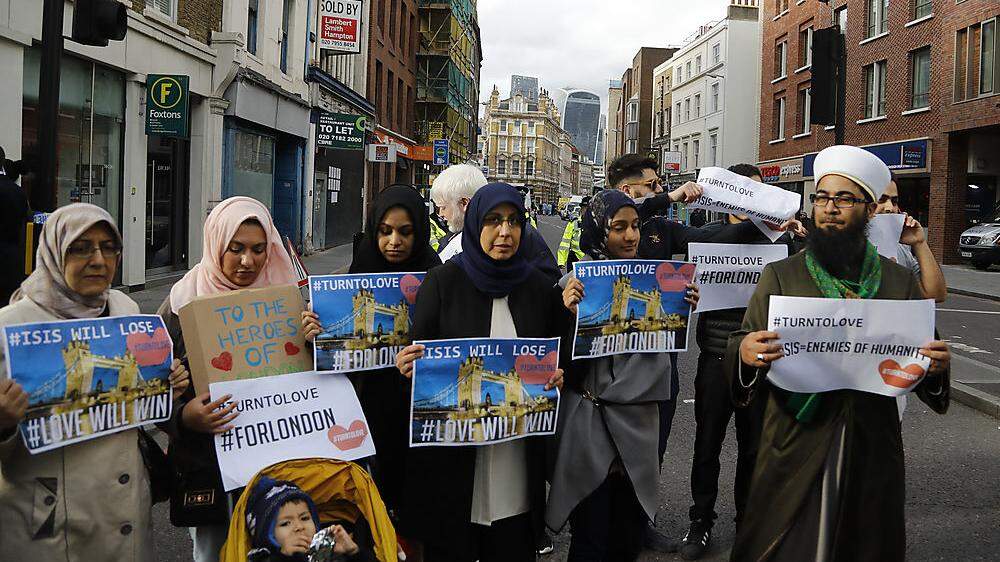 Muslime marschieren mit Schildern durch die Stadt: &quot;IS wird verlieren&quot;, &quot;IS - Feinde der Menschheit&quot;, &quot;Haltet euch an die Liebe&quot;...