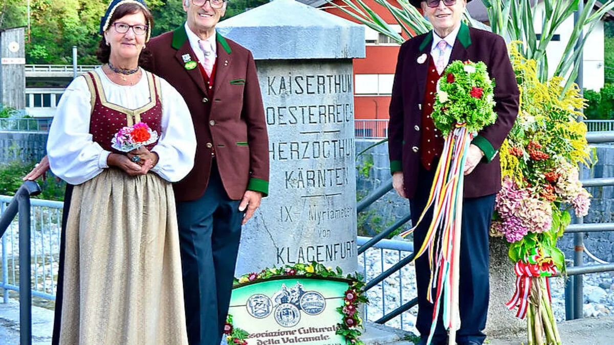 Giuliana Pallanch, Hans Preschern und Raimondo Domenig  vom Kanaltaler Kulturverein vor dem historischen Grenzstein