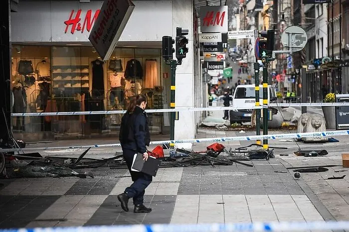 In der Innenstadt von Stockholm liegen orangefarbene Rettungsdecken immer noch auf dem Asphalt. Gerüste und Absperrbänder der Polizei umschließen den Tatort auf der belebten Einkaufsstraße Drottninggatan, an dem ein Lkw am Freitagnachmittag in eine Menschenmenge gerast ist und vier Menschen getötet hat.