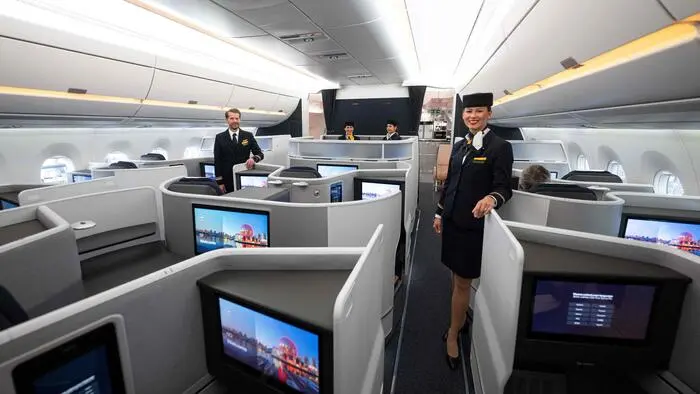 Crew members of German airline Lufthansa pose inside the Airbus A350-900 Leipzig to present the new long-haul Business Class cabin called 'Allegris' during a press event at Munich International Airport in Munich, southern Germany, on April 25, 2024. From May 2024, passengers will be able to travel for the first time inside the new cabin in an Airbus A350-900. (Photo by LUKAS BARTH / AFP)
