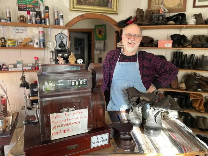 Franz Georg Bernhard in seinem Verkaufsraum mit der Kassa aus dem Jahr 1938