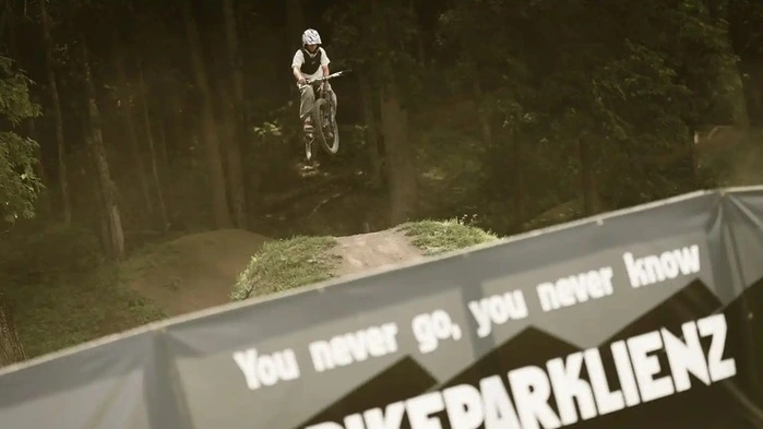 Ein Mountainbiker zeigt einen Trick im Bikepark Lienz