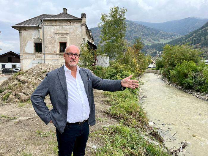 Treffens Bürgermeister Klaus Glanznig verweist auf den Treffnerbach, im Hintergrund das alte Wasserschloss, das ebenfalls abgelöst werden soll
