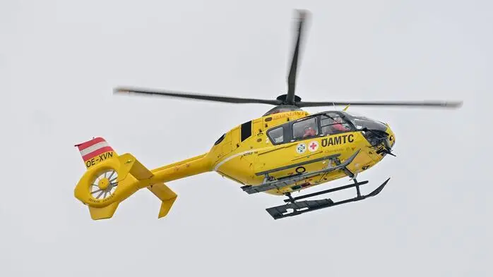 Man sieht einen gelben Hubschrauber in der Luft