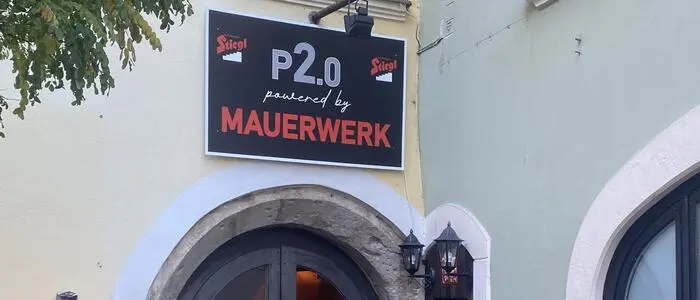 Eingangstor zu einem Lokal, darüber ein Schild mit der Aufschrift „P2.0 powered by Mauerwerk“