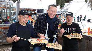 Wenjn Sheng, Wirt Rudi Strablegg und Cuixiao Wui servieren den Gästen frisches Sushi 