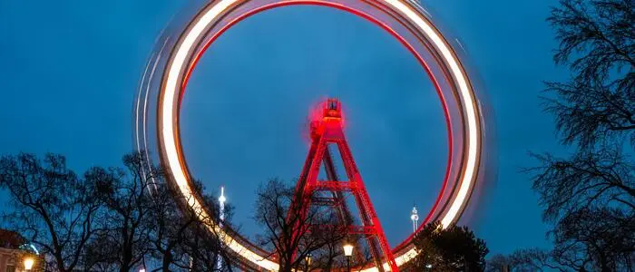 Das Wiener Riesenrad als rotes Rad in einer Aufnahme mit Langzeitbelichtung | Das rote Rad dreht sich in Wien weiter – nicht nur im Prater, sondern auch im Rathaus