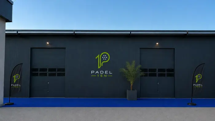 Außenansicht einer dunklen Halle mit Logos drauf
