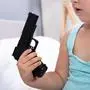 Close-up Of A Girl's Hand Holding Gun At Home
