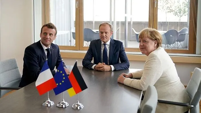 Mit passenden Fähnchen: Macron, Tusk, Merkel