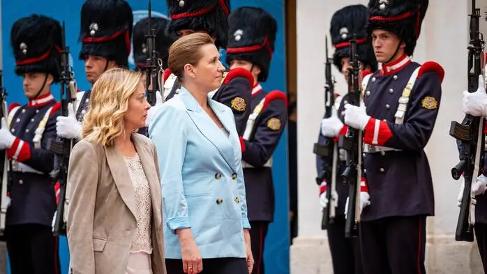 Giorgia Meloni und Mette Frederiksen gehen vor Mitgliedern der italienischen Ehrengarde.
