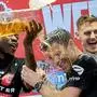 Leverkusen's head coach Xabi Alonso , centre, is sprayed with beer after Bayer Leverkusen won the German Bundesliga title beating Werder Bremen in Leverkusen, Germany, Sunday, April 14, 2024. (AP Photo/Martin Meissner)