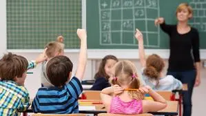 Kinder in einer Schulklasse zeigen auf, Lehererin an der Tafel | Trotz Veränderungen: Musikschwerpunkt soll wertvoller Teil der Lavanttaler Bildungslandschaft bleiben