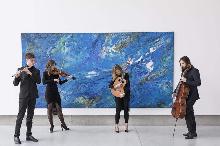 Sonusiade-Musiker vor dem Hintergrund eines Gemäldes von Roman Scheidl