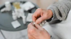 Close up of an elderly hand holding pills.
