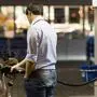 Young man fueling his car at the gas station