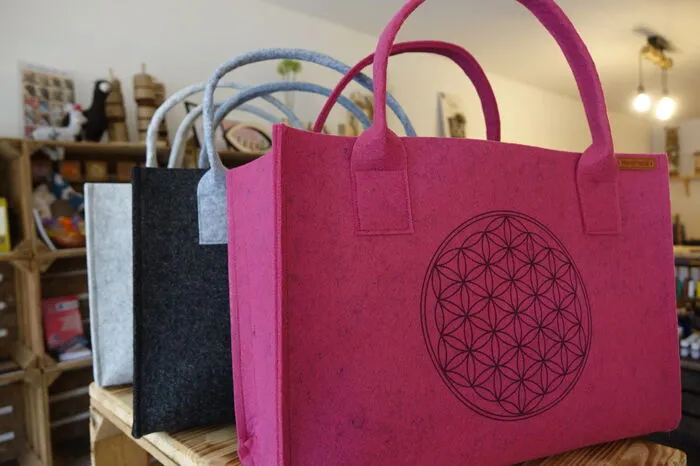 Filztaschen in vielen Farben warten auf Käuferinnen.