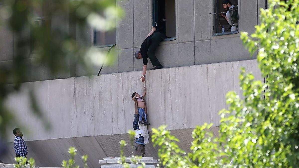 Dramatische Szenen am Parlamentsgebäude in Teheran: Ein Kind wird aus dem Parlamentsgebäude evakuiert